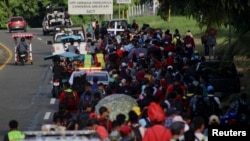 Migrants walk along the road in a caravan in an attempt to reach the U.S border, in Tapachula, Mexico Nov. 5, 2023. 