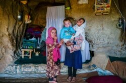 Anak-anak etnis Hazara berdiri di gua mereka, di tebing yang pernah dihuni berabad-abad lalu di Bamiyan, Oktober 2021. (Foto: Bulent KILIC / AFP)