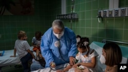 A nurse takes a girl's blood pressure after giving her a dose of the Cuban-made Soberana vaccine for COVID-19 in Havana, Cuba, Aug. 24, 2021.