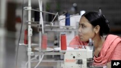 FILE - Bangladeshi garment worker Asma, who worked on the 4th floor of Rana Plaza garment factory that collapsed exactly a year ago, works at a factory meant to rehabilitate survivors of the accident, the worst in the history of the garment industry, in S