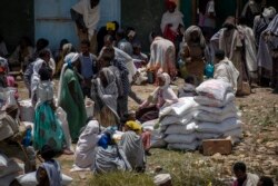 Seorang perempuan Ethiopia duduk di atas karung gandum yang dibagikan oleh Lembaga Bantuan Tigray di kota Agula, wilayah Tigray, Ethiopia utara, 8 Mei 2021.