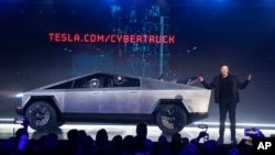 Tesla CEO Elon Musk introduces the Cybertruck at Tesla's design studio Thursday, Nov. 21, 2019, in Hawthorne, Calif. Musk is taking on the workhorse heavy pickup truck market with his latest electric vehicle. (AP Photo/Ringo H.W. Chiu)