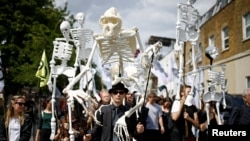 FILE - Extinction Rebellion activists march through East London, Britain, July 13, 2019. 