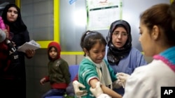 FILE - A Syrian girl cries after being vaccinated against the measles at a U.N. registration center in Zahleh, in Lebanon's Bekaa Valley.