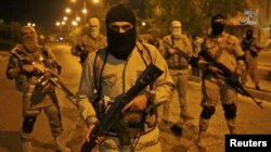 A still image taken from an Islamic State (IS) video released through the group's Amaq news agency shows an unidentified militant addressing the camera. The video is said to be shot in Mosul, Iraq, Oct. 18, 2016.