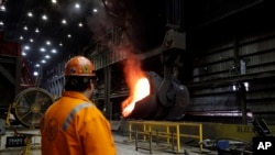 FILE- Senior melt operator Randy Feltmeyer watches a giant ladle backing away after pouring its contents of red-hot iron into a vessel in the basic oxygen furnace as part of the process of producing steel at the U.S. Steel Granite City Works facility in Granite City, Ill., June 28, 2018,