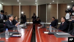FILE - Hwang Boogi, left, South Korea's vice minister of unification and the head negotiator for high-level talks with North Korea, talks as his North Korean counterpart Jon Jong Su, right, listens during their meeting.