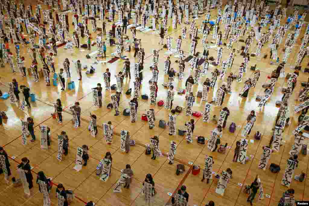 Pupils hold sheets with kanji characters they wrote during a calligraphy contest to celebrate the New Year in Tokyo, Japan.