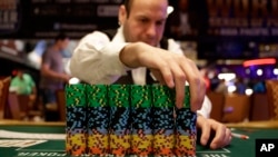 FILE - A dealer adjusts a stack of chips before the first day of the World Series of Poker main event, a Texas hold 'em competition, in Las Vegas, Nov. 10, 2014.
