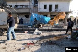 Residents inspect the damage as blood stains are seen on the ground after airstrikes by pro-Syrian government forces in the rebel-held al-Sakhour neighborhood of Aleppo, Syria, Feb. 8, 2016.
