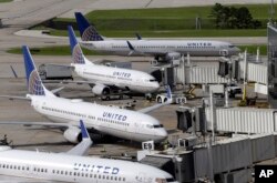 FILE - United Airlines planes are parked at their gates as another plane taxis past them at George Bush Intercontinental Airport in Houston, July 8, 2015.