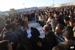FILE - People attend the funeral of policemen killed in a truck bomb blast at a police training school in the western Libyan town of Zliten, Jan. 7, 2016.