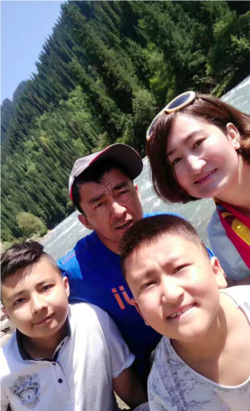 在这张日期不明的照片中，热纳古尔·艾尼与孩子和丈夫合影。(照片由坎比努尔·艾尼提供)