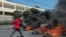 A protester burns tires during a demonstration following the resignation of its Prime Minister Ariel Henry, in Port-au-Prince, Haiti, on March 12, 2024.