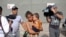 Adalicia Montecino and her husband Rolando Bueso Castillo are surrounded by the media as they walk with their year-old son Johan Bueso Montecinos, who became a poster child for the U.S. policy of separating immigrants and their children, in San Pedro Sula, Honduras, Friday, 20, 2018.