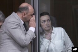 FILE - Alsu Kurmasheva, an editor for VOA sister outlet Radio Free Europe/Radio Liberty, listens to her lawyer during a court hearing in Kazan, Russia, on April 1, 2024.