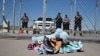 FILE- Shoes and a teddy bear, brought by a group of U.S. mayors, are piled up outside a holding facility for immigrant children in Tornillo, Texas, near the Mexican border, June 21, 2018.