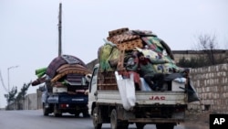 Syrians drive through the city of al-Mastouma, in Idlib province, as they flee a government offensive, Jan. 28, 2020.