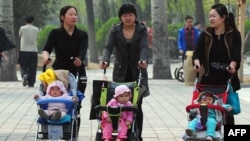 Women push babies in prams through a Beijing park during a public holiday, April 5, 2011.