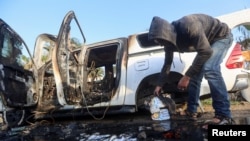 গাজার কেন্দ্রস্থলে একজন ফিলিস্তিনি একটি গাড়ি দেখছে যেখানে ওয়ার্ল্ড সেন্ট্রাল কিচেনের কর্মীরা ইসরাইলি বিমান হামলায় নিহত হন। এপ্রিল ২, ২০২৪। 