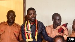 FILE - Uganda's prominent opposition politician Robert Kyagulanyi known as Bobi Wine (2L) appears at the chief magistrate court in Gulu, northern Uganda, on Aug. 23, 2018. 