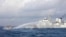 In this handout photo provided by the Philippine Coast Guard, a Chinese Coast Guard ship uses water cannons on Philippine navy-operated supply boat M/L Kalayaan as it approaches Second Thomas Shoal in the disputed South China Sea on Dec. 10, 2023. (Philippine Coast Guard via AP)
