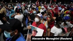 Seorang pria membawa foto mantan presiden Kuba dan Sekretaris Pertama Partai Komunis, Raul Castro, dalam unjuk rasa terkait kekhawatiran pandemi COVID-19 di Havana, Kuba, 17 Juli 2021. (Foto: Alexandre Meneghini/Reuters)