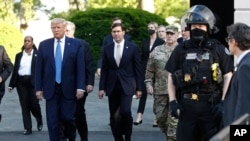 FILE - President Donald Trump departs the White House to walk to St. John's Church in Washington, June 1, 2020. Defense Secretary Mark Esper is to Trump's right.