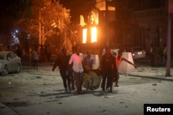 Rescue workers evacuate an injured man from the scene where a suicide car bomb exploded targeting a Mogadishu hotel in a business center at Maka Al Mukaram street in Mogadishu, Somalia. Feb. 28, 2019.