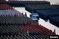 Russian Defense Minister Sergei Shoigu and Chief of the Russian Land Forces Oleg Salyukov salute to soldiers as they are driven along Red Square during a rehearsal for the Victory Day military parade in Moscow, May 7, 2019.