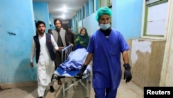 Afghan men transport the body of one of three female media workers who were shot and killed by an unknown gunmen, at a hospital in Jalalabad, Afghanistan, March 2, 2021.