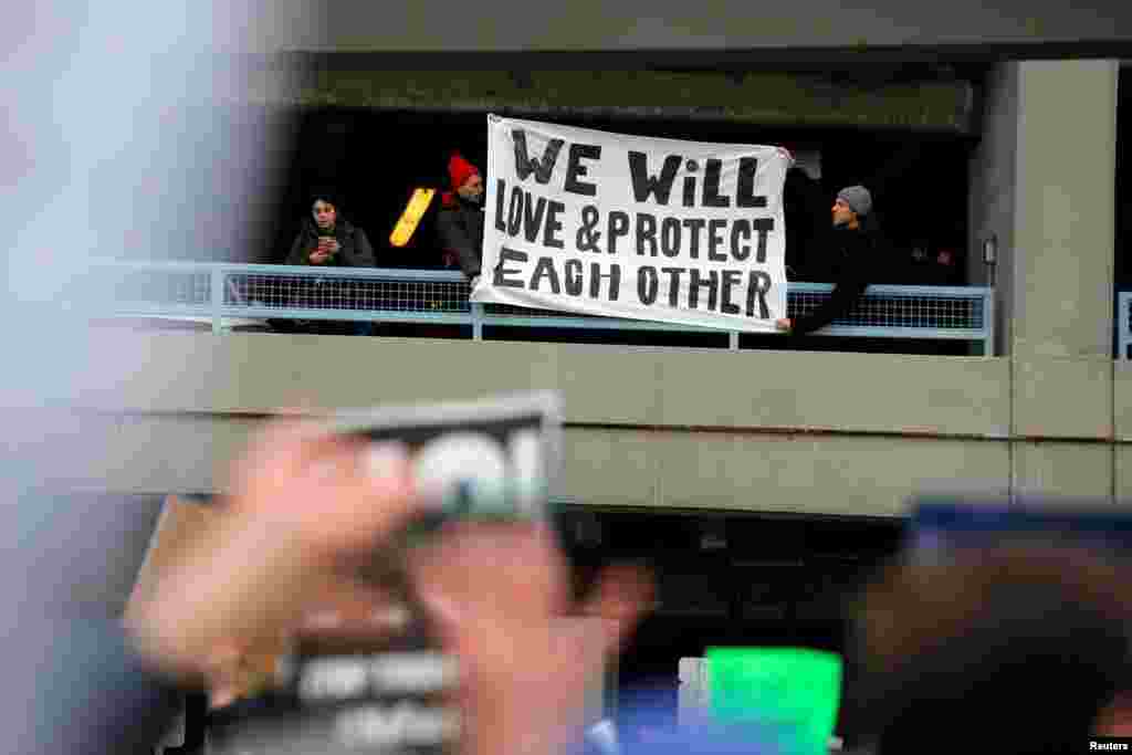 Demonstrators hang a banner from a multi-level car park during a protest against Donald Trump's travel ban outside Terminal 4 at John F. Kennedy International Airport in Queens, New York, Jan. 28, 2017. 