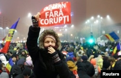 FILE - A woman holds up a sign that reads "Government without corruption" during a demonstration of thousands of Romanians against their government in Bucharest, Feb. 6, 2017.