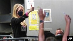 Georgia Senator Kelly Loeffler gives the thumbs up as she is recognized by President Donald Trump during his visit to Georgia to talk about an infrastructure overhaul, July 15, 2020, in Atlanta.