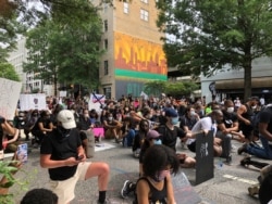 Protesters observe a moment of silence during a march, June 6, 2020, in Atlanta. Demonstrations continue across the U.S. against racism and police brutality, sparked by the May 25 death of George Floyd in police custody in Minneapolis.