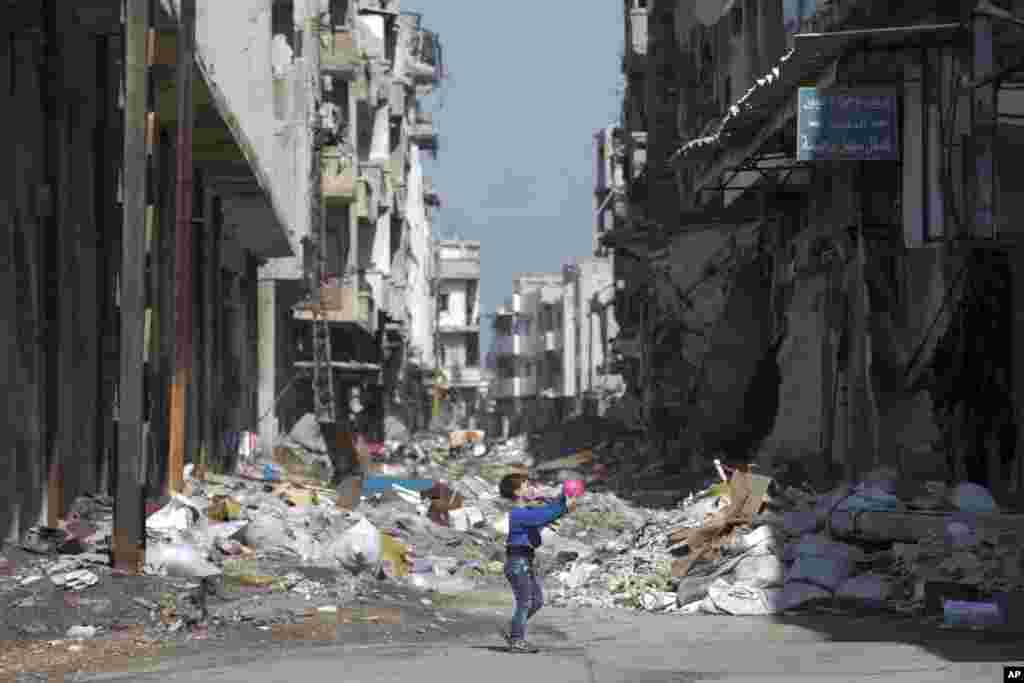 A Syrian boy plays between destroyed buildings in the old city of Homs, Syria. The U.N. Security Council is expected to vote Friday afternoon on a draft resolution endorsing the "cessation of hostilities" in Syria that is set to start at midnight local time.