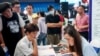 FILE - University graduates attend a job fair in Wuhan, in China's central Hubei province, Aug. 10, 2023. As the economy slows, many young Chinese are sharing their money-saving tips on social media.