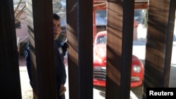 FILE - A man in Nogales, Sonora, Mexico looks through the U.S. border fence into Nogales, Arizona, U.S., January 31, 2017.