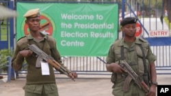 Des officiers de police armés montent la garde devant le centre des résultats de l'élection présidentielle à Lusaka, en Zambie, le 21 janvier 2015.