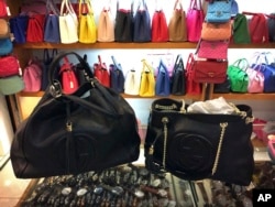 FILE - Counterfeit branded bags appear on display in a room hidden from the public area of a popular shopping mall in Beijing, China, March 11, 2015.