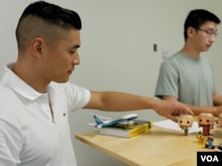 Listia co-founder James Fong, foreground, displays some of the collectibles traded on the website. (M. O'Sullivan/VOA)