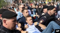 Des policiers transportent le leader de l'opposition Alexeï Navalny, au centre, lors d'une manifestation contre le président Vladimir Poutine sur la place Pouchkine à Moscou, Russie, le 5 mai 2018.