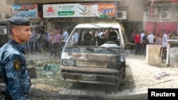 An Iraqi security officer inspects the site of a bomb attack in the Karrada district of Baghdad, May 30, 2013.