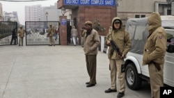 Indian police officers stand outside the district court where five men accused in a gang rape were brought to appear in New Delhi, January 7, 2013. 