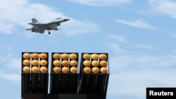 Jet tempur F-16 milik Angkatan Udara Taiwan melintas di atas Thunderbolt-2000, Sistem Peluncuran Roket Ganda, dalam parade di pangkalan udara Ganghshan, di Kaohsiung, Taiwan, 7 Agustus 2017. (Foto: Reuters)