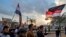 Iraqi protesters march with national flags and a Shiite Muslim flag during an anti-government demonstration in the southern Iraqi city of Basra on Nov. 29, 2019. 