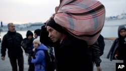 Refugees and migrants disembark from a ferry at Athens' main port of Piraeus, Jan 27, 2016.