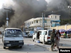 A Somali government soldier evacuates a woman, injured during an explosion, in KM4 street in the Hodan district of Mogadishu, Somalia, Oct. 14, 2017.