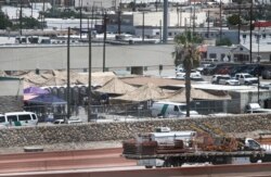 Migrants are seen in a fenced-off area an outdoor encampment where they’re waiting to be processed in El Paso, Texas, June 12, 2019. The Trump administration is facing growing complaints about severe overcrowding, meager food and other hardships.