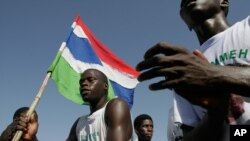 De jeunes gambiens célèbrent avec le drapeau de leur pays au bord de la plage à Banjul, Gambie, 23 2006